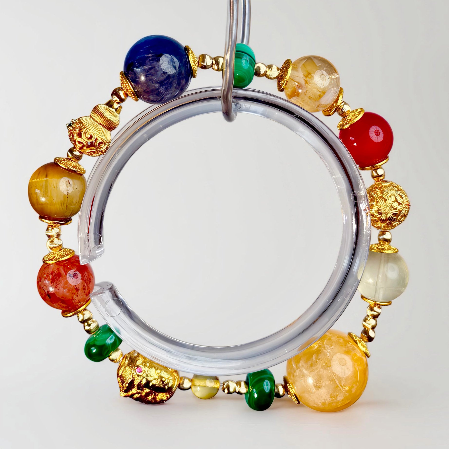 Handcrafted multicolor gemstone bracelet with turquoise, agate, crystal, and gold details, centered with a symbolic gourd and three-faced bead, embodying harmony, balance, and refined energy.