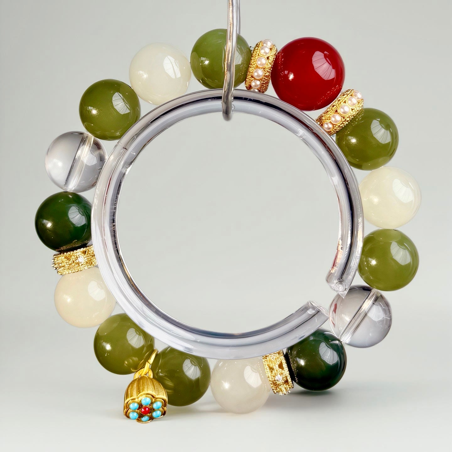 Handcrafted Hetian jade bracelet with red and white accents and lotus motif, embodying clarity, awareness, and refined Eastern symbolism.